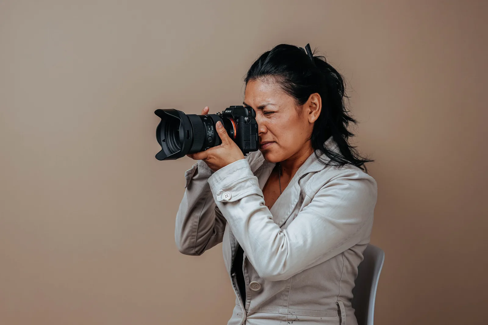 Portrait of a woman in a studio setting using a professional camera. Photography equipment brands for portrait studios: what each one does well