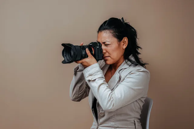 Portrait of a woman in a studio setting using a professional camera. Photography equipment brands for portrait studios: what each one does well